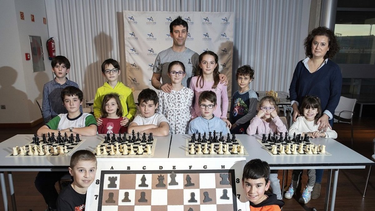 Nacho, en primer plano a la izquierda, posa junto a sus compañeros del Club Ajedrez Arroyo en el centro de cultura de La Flecha junto a los tableros de ajedrez. J.M. LOSTAU