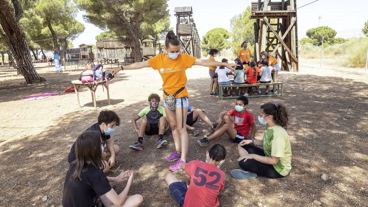 Una monitora realiza un juego ante la atenta mirada de los niños y niñas del campamento urbano de El Pinar de Antequera. - MIGUEL ÁNGEL SANTOS