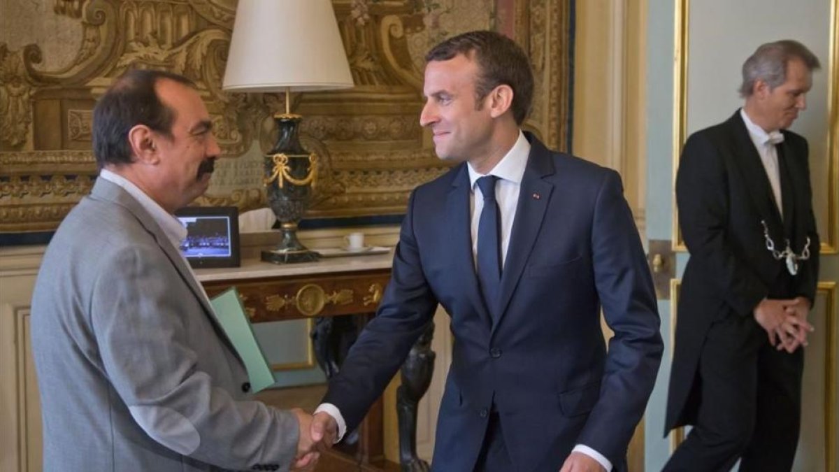 Macron (derecha) saluda al líder de la CGT, Philippe Martinez, en el palacio del Elíseo, en París, el 23 de mayo.-REUTERS