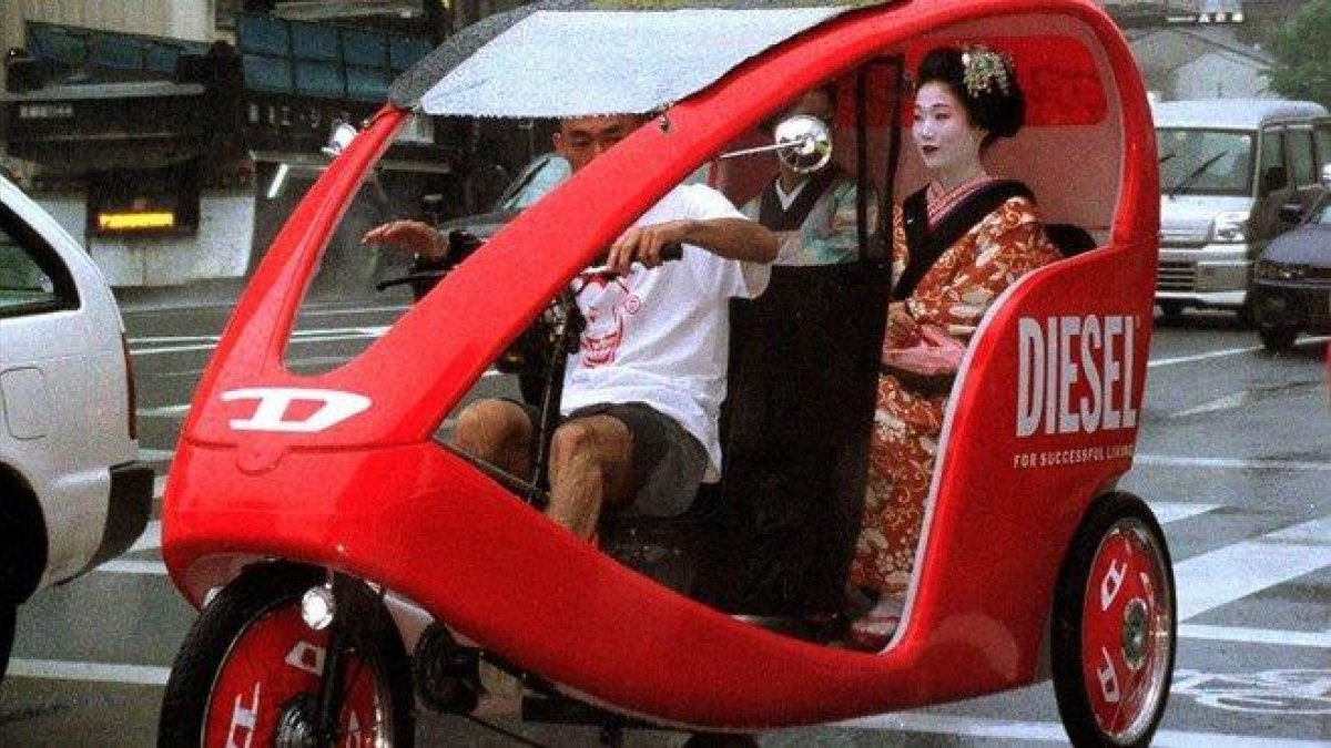 Una geisha se desplaza en un taxi triciclo por Kioto.-ISAO MORISHITA (AP)