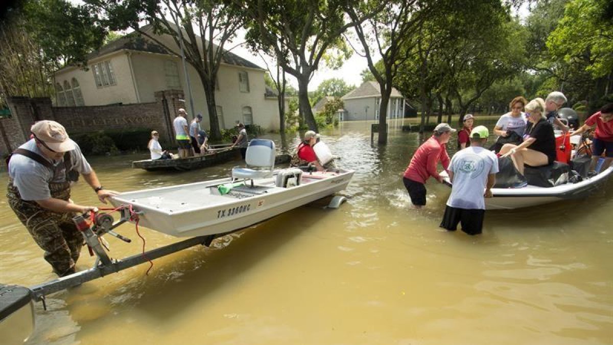 Voluntarios fueron registrados este viernes al ayudar a residentes a volver a sus casas por algunas pertenencias, tras las lluvias que provocó a su paso el huracán Harvey, en Houston (Texas, EE.UU.).-EFE