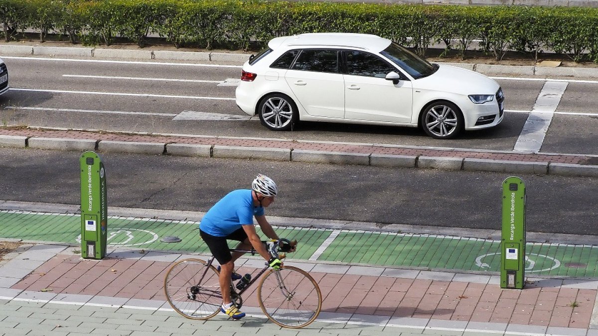 Un ciclista pasa por delante de uno de los puntos de recarga eléctrica de Valladolid. / PHOTOGENIC / MIGUEL ÁNGEL SANTOS