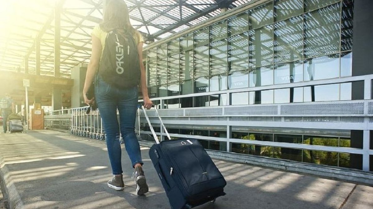 Una joven lleva su maleta en un aeropuerto.- E.M.
