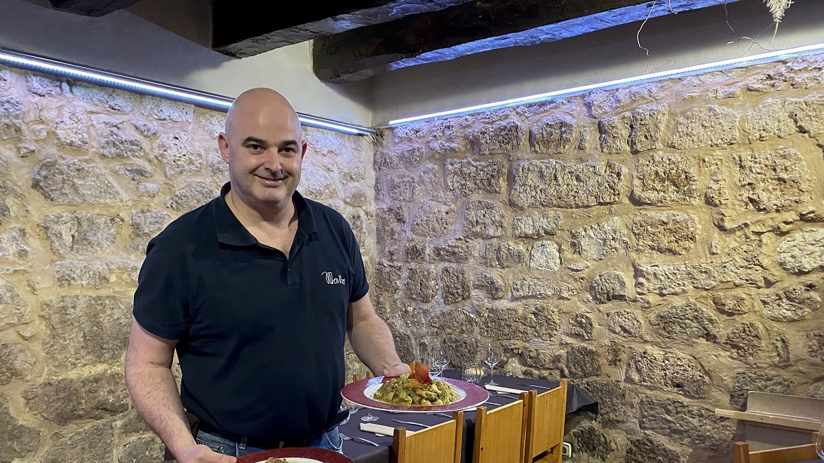 Alberto Beltrán, con una ración de patatas a la importancia y otra de menestra, en el comedor del restaurante Maño.- E.M.