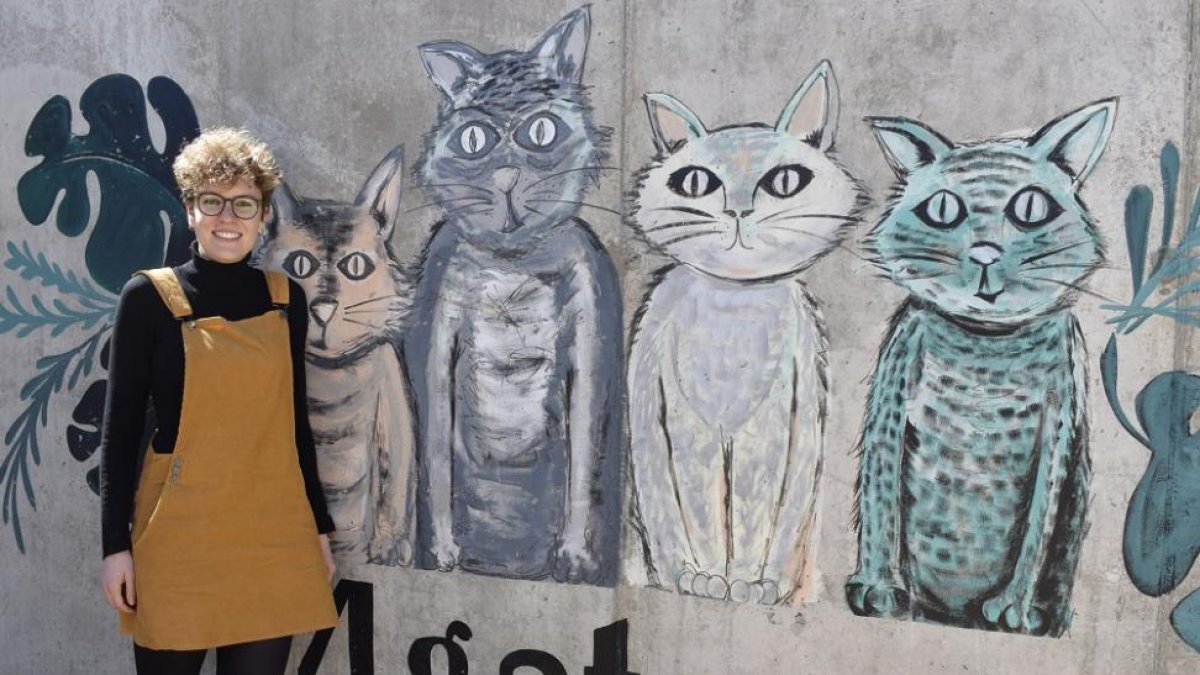 Virginia Hernández, junto al mural de los cuatro gatos, situado en la denominada ‘zona de convivencia’ de su pueblo, cuya autora es Icíar Gil, diseñadora de origen arandino a quien le unen lazos de amistad con San Pelayo.-ARGICOMUNICACIÓN