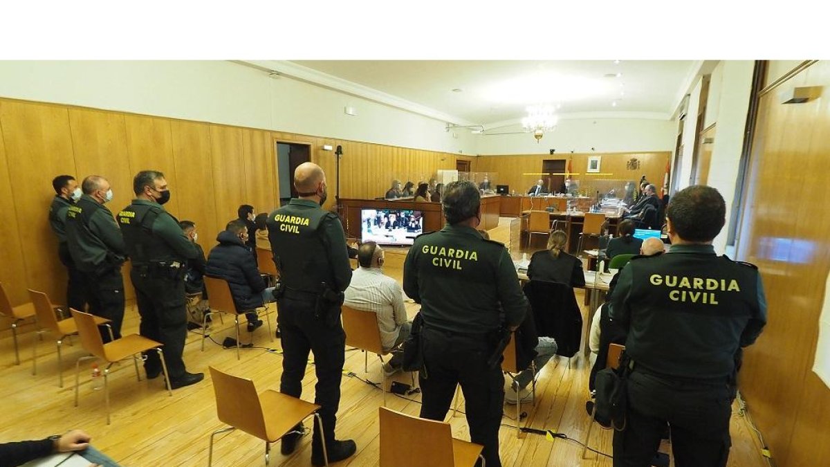 Guardias civiles detrás de cada acusado ayer, en el inicio del juicio con jurado del crimen de la Cicular. P. REQUEJO / PHOTOGENIC