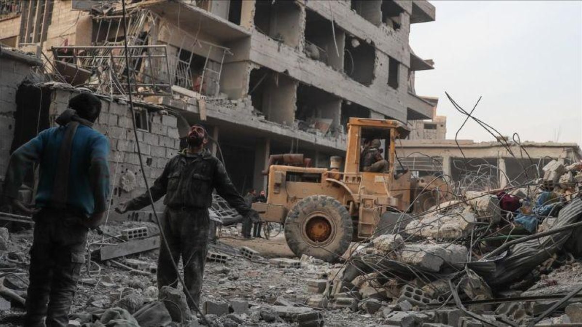 Civiles y voluntarios de la Defensa Civil Siria buscan sobrevivientes tras varios ataques aéreos en la ciudad de Hamoria, en Guta.-EFE / MOHAMMED BADRA