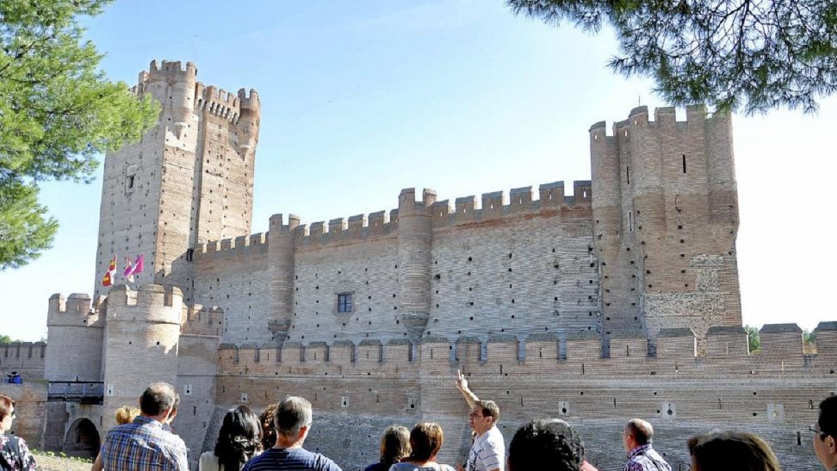 Un grupo de visitantes atiende al guía en el Castillo de La Mota, una de las paradas de la ‘Ruta de Fernando’.-Santiago