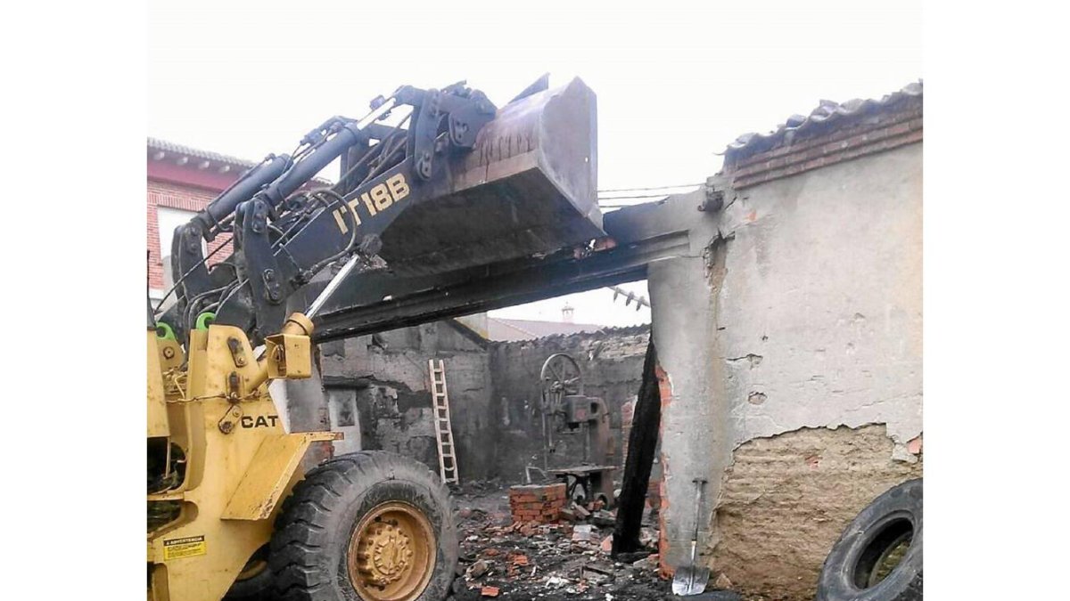 Una excavadora derriba el inmueble calcinado en la noche del martes en la calle Estación de Ataquines-El Mundo