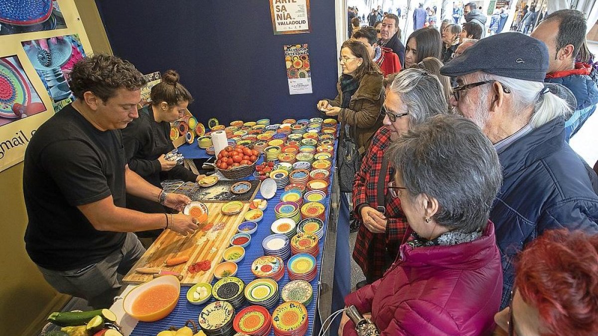 Asistentes observan como elaboran un plato tradicional durante la XXVII feria de artesanía de Valladolid.-J.M. LOSTAU