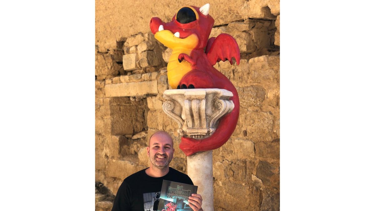 Juan Villa posa con una copia del libro delante de una escultura de Triguerito | E.M