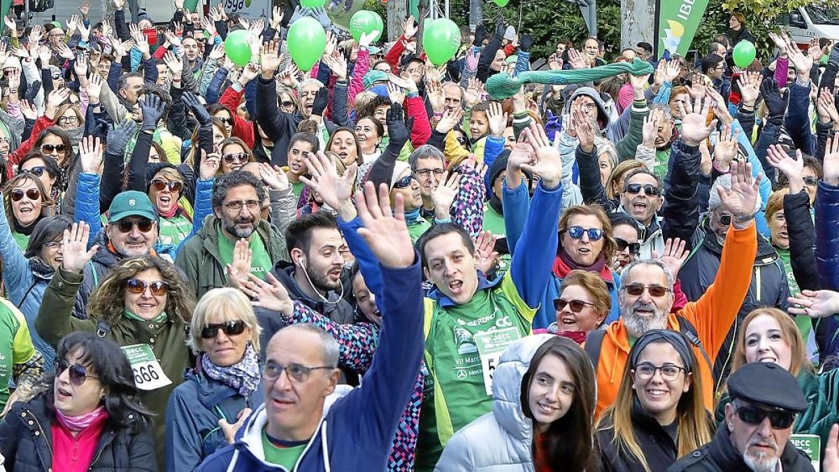 Parte de la marcha alza la mano para apoyar a los pacientes de cáncer y a sus familiares, que también se ven afectados por esta enfermedad.-J.M. LOSTAU