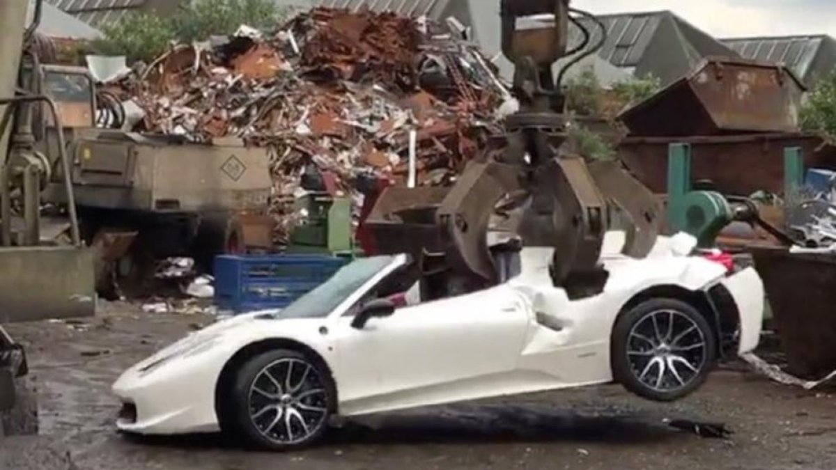 El Ferrari 458 Spider siendo destrozado por una grúa en un desguace.-/ HOTSPOT MEDIA