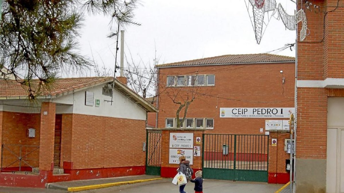 Una madre y su hijo pasan por delante del colegio Pedro I de Tordesillas, uno de los eliminados del programa.-Santiago