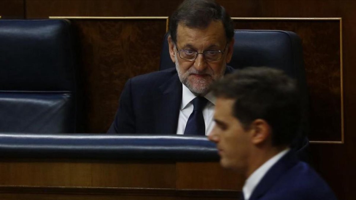 El líder de Cs, Albert Rivera, pasa por delante del presidente del Gobierno, Mariano Rajoy, en el Congreso de los Diputados.-/ AGUSTIN CATALAN