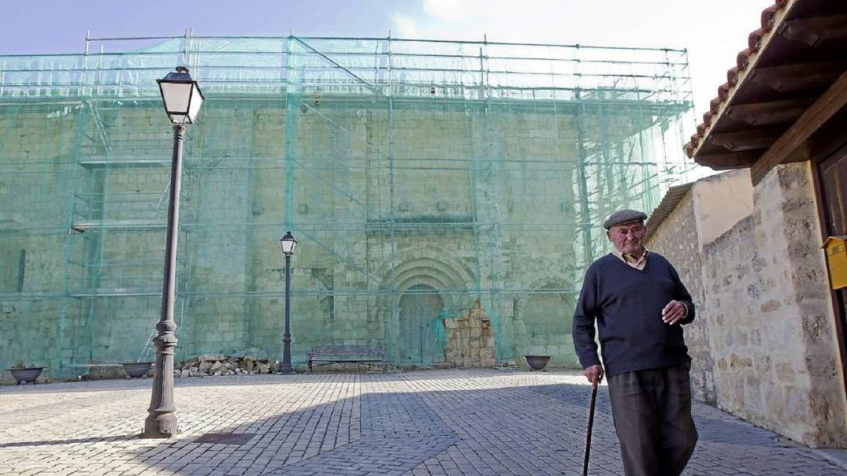 Un vecino de Villalba pasea por la plaza donde se ubica el BIC, ya cubierto para su remodelación-J.M.Lostau