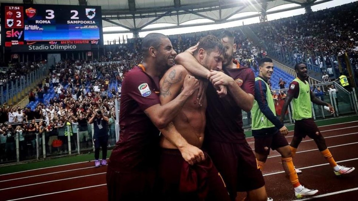 Totti es abrazado por sus compañeros del Roma tras marcar de penalti el gol de la victoria contra el Sampdoria.-AP / ANGELO CARCONI