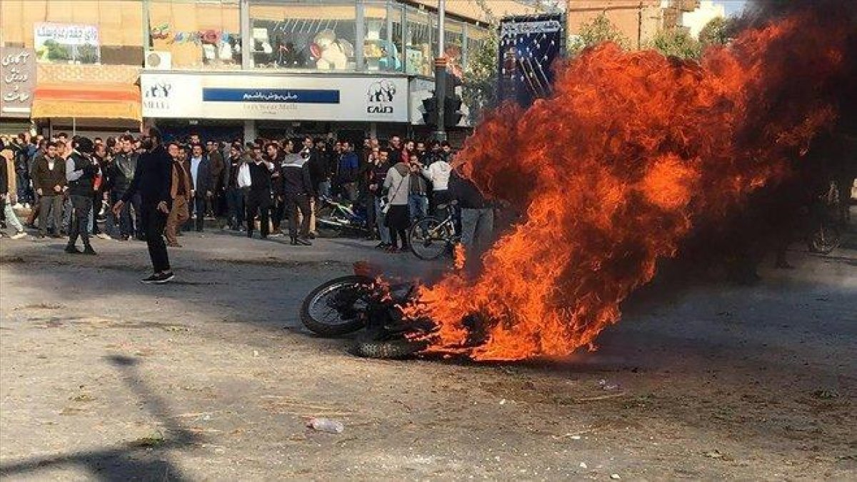 Manifestantes iranís junto a una motocicleta quemada en Isfahan (Irán).-AFP