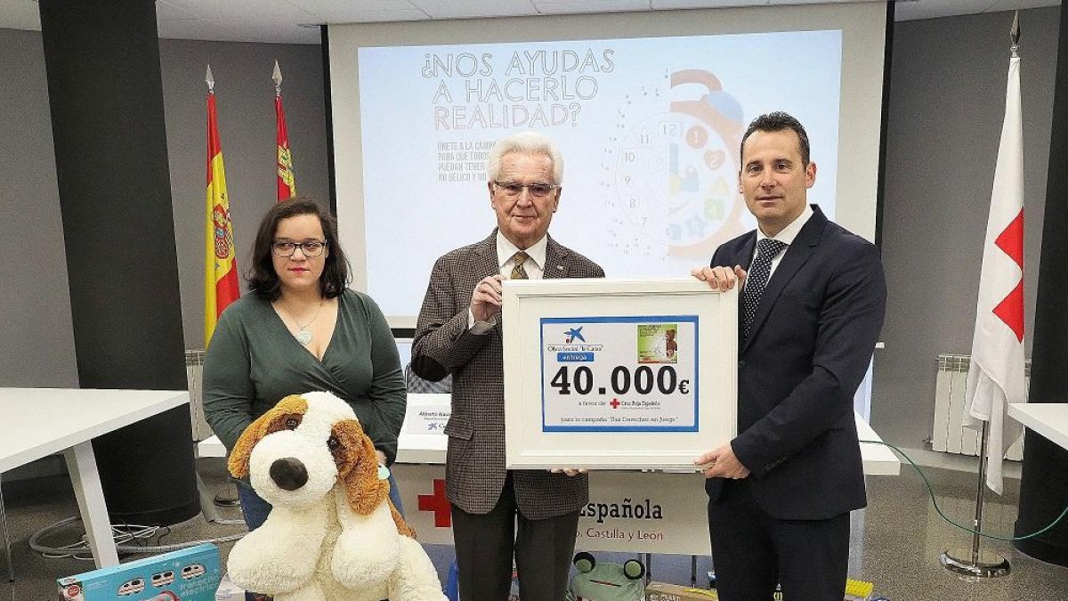 Representantes de Cruz Roja y de CaixaBank posan con el importe entregado por la entidad.-PABLO REQUEJO / PHOTOGENIC