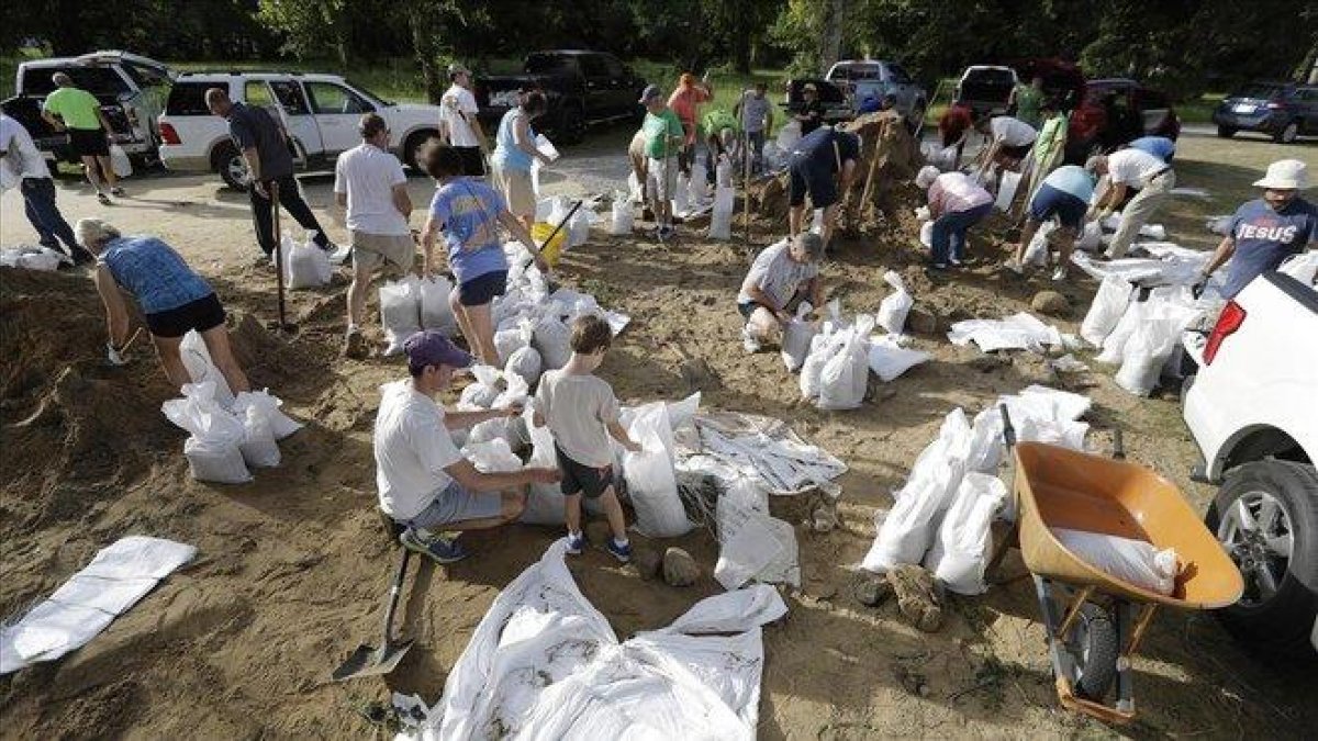 Vecinos de Baton Rouge colocan bolsas de arena para afianzar estructuras ant la inminente llegada de ’Barry’.-DAVID J. PHILLIP (AP)