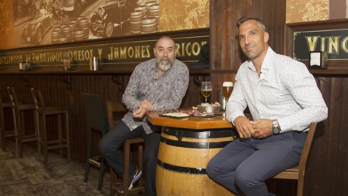 El piragüista EmilioMerchán (d) comparte caña y jamón con el propietario de la cervecería-restaurante El Colmado, de Zamora, José ManuelPrieto.-M. DENEIVA