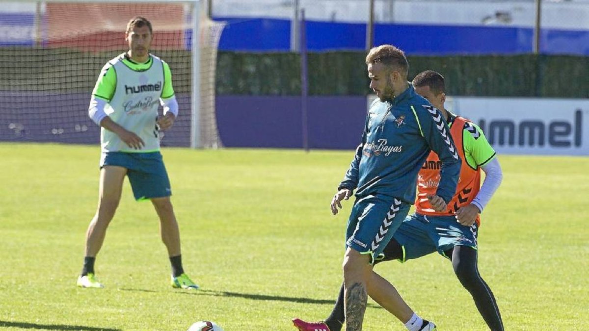 Roger da un pase durante el entrenamiento de ayer, ante la presión de Peña y la mirada de Samuel-P. REQUEJO