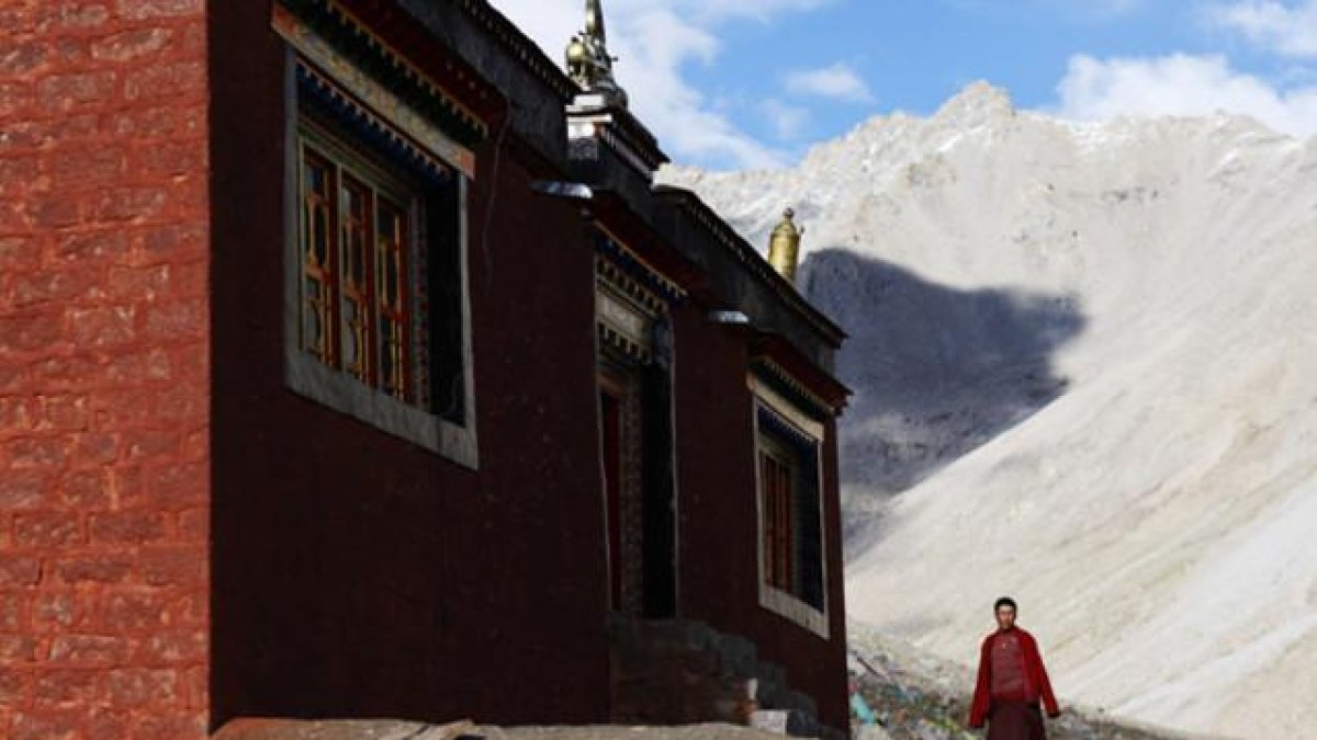 Un monje tibetano junto a la entrada del templo budista del monte Kailash en Ngari (Tíbet).-JACKY CHEN / REUTERS