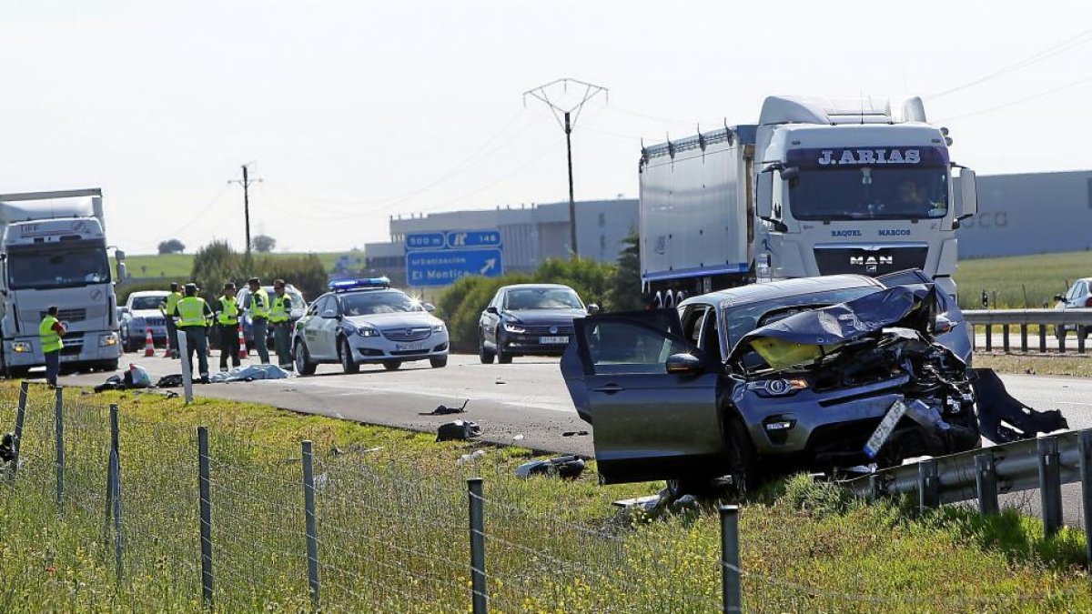 Agentes de la Guardia Civil levantan ayer atestado junto al cadáver de su compañero. En primer término, el todoterreno que lo habría arrollado.-J. M. LOSTAU