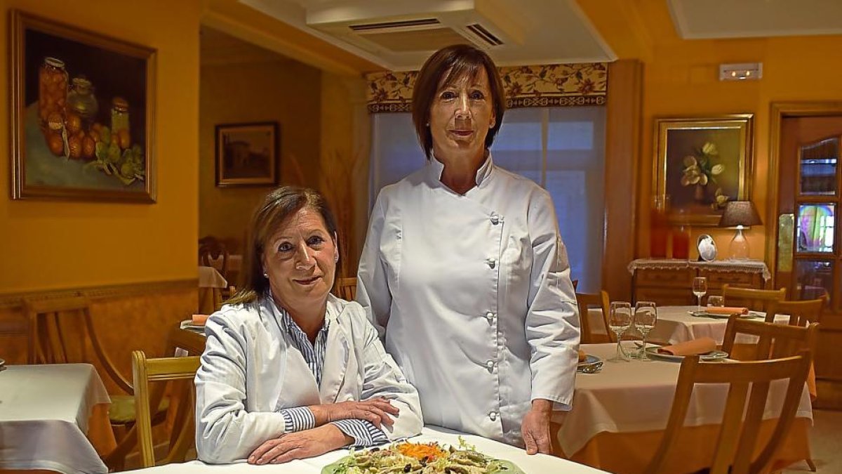 Las hermanas Josefina y Araceli, en el comedor del restaurante familiar de Salas de los Infantes, con algunos platos representativos de la casa.-ARGICOMUNICACIÓN