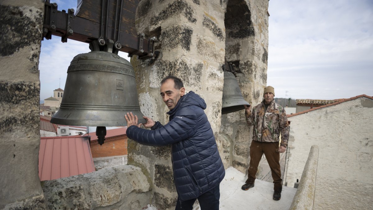Jesús Serrano, en primer plano, y Fernando del Río, hacen sonar las campanas de la iglesia de San Esteban de la localidad deSan Miguel delArroyo. PEDRO ARRANZ