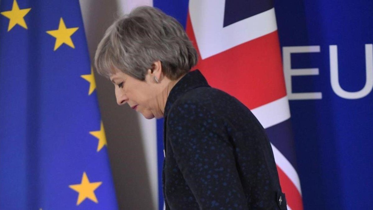 La primera ministra británica, Theresa May, pasa ante las banderas de la UE y del Reino Unido tras celebrar una rueda de prensa en Bruselas.-EMMANUEL DUNAND (AFP)