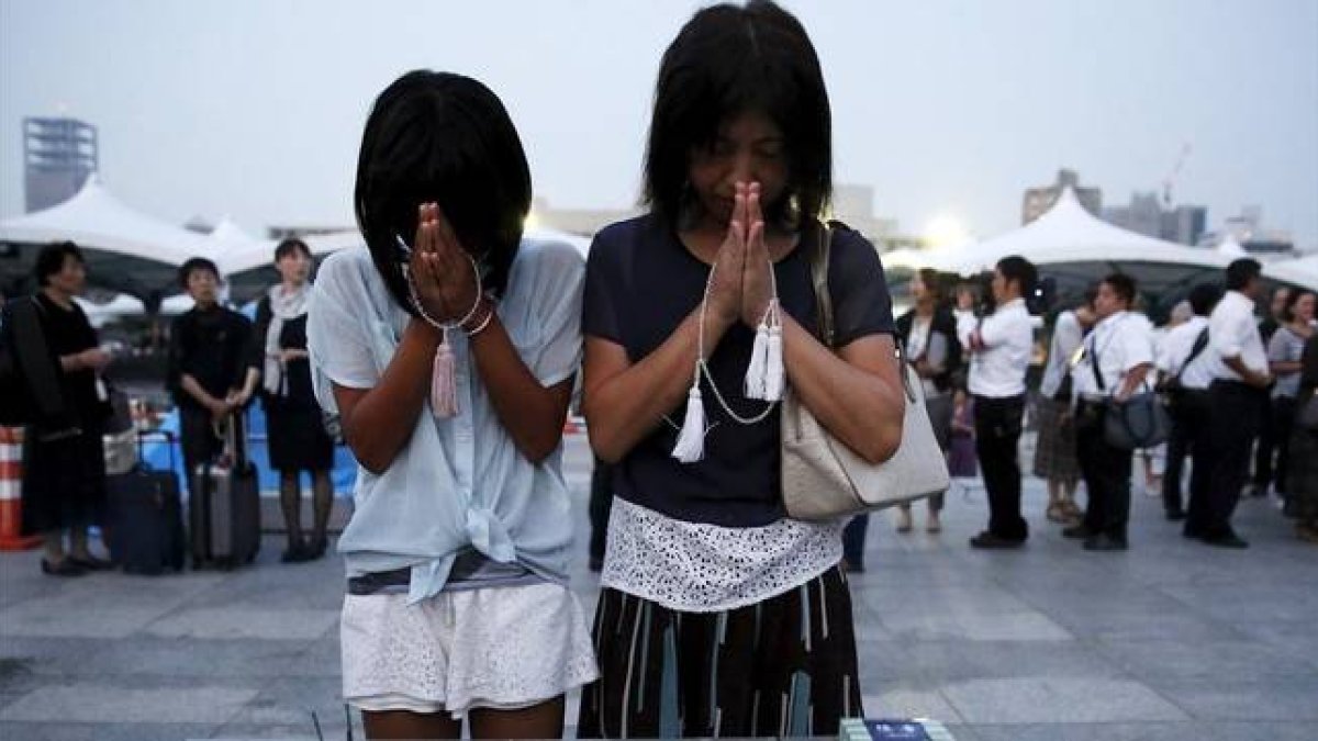 Una madre y una hija oran en la ceremonia celebrada en el Parque Memorial de la Paz.-Foto: REUTERS / TORU HANAI