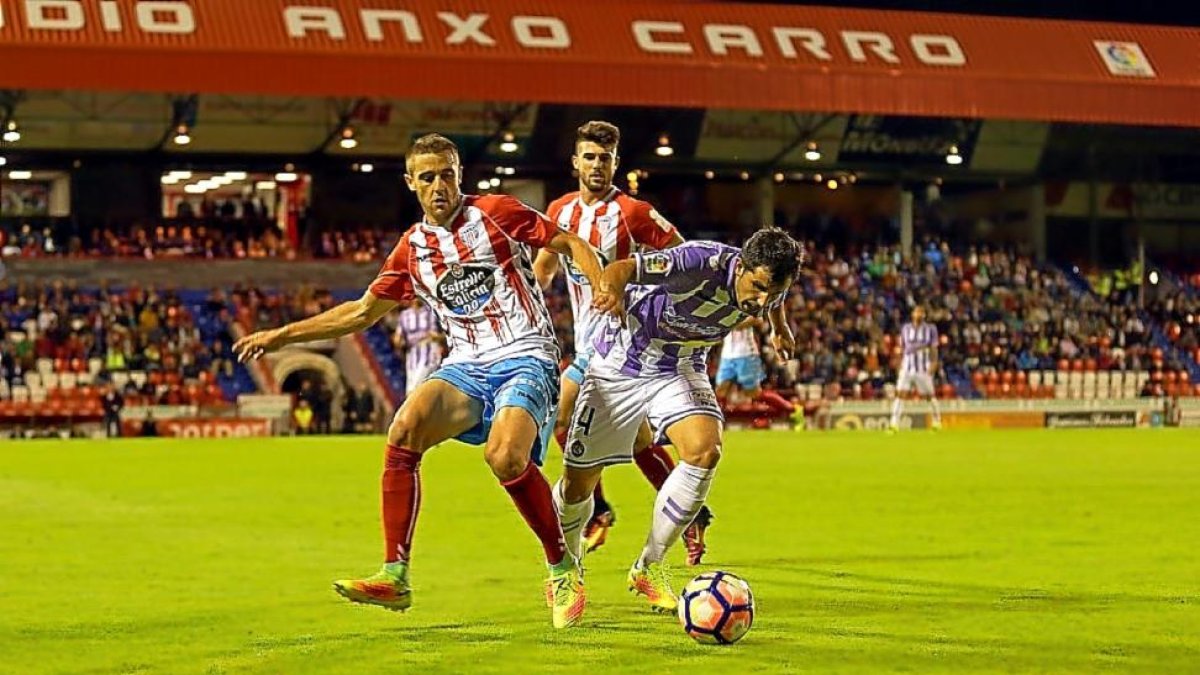 Álex López intenta eludir el marcaje de Miquel y Jordi en el partido disputado en el Anxo Carro.-PHOTO-DEPORTE