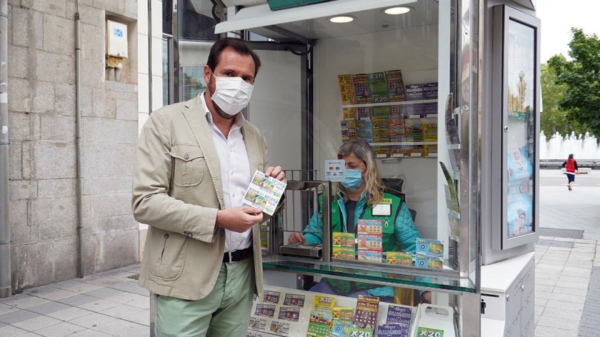 El alcalde de Valladolid, Óscar Puente, compra un cupón a un vendedor de la ONCE que vuelve a vender en la calle tras el confinamiento por la COVID-19. - ICAL