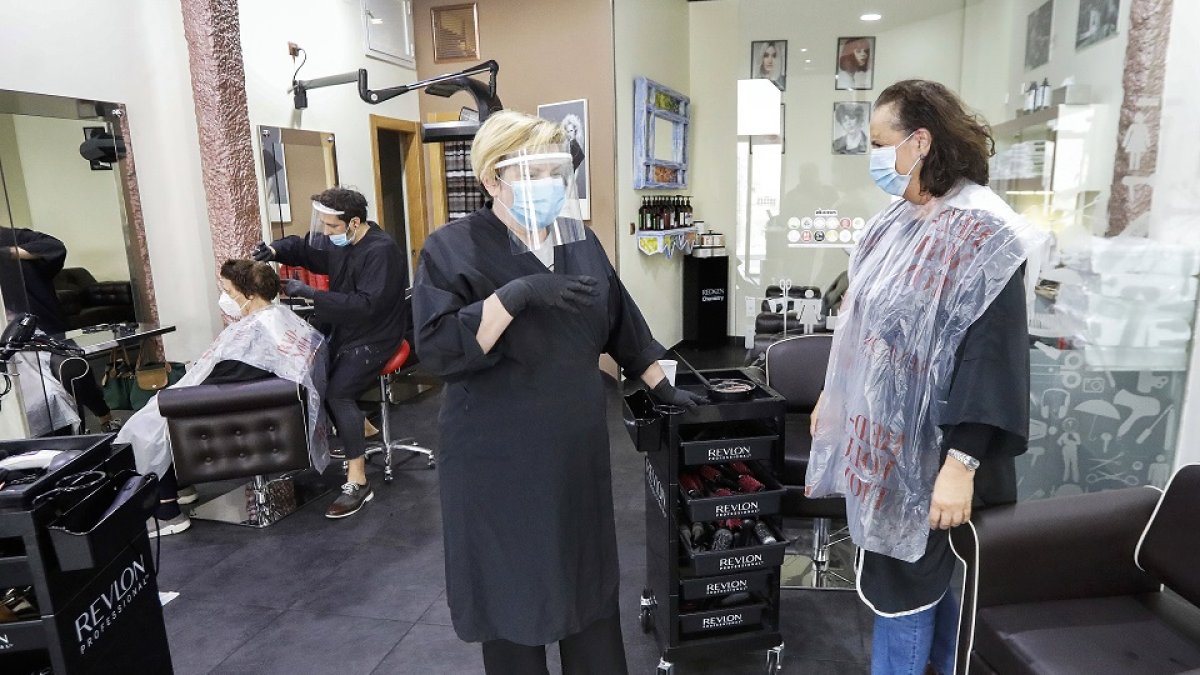 Una peluquera conversa con una clienta en un comercio del centro de Valladolid. J.M. LOSTAU