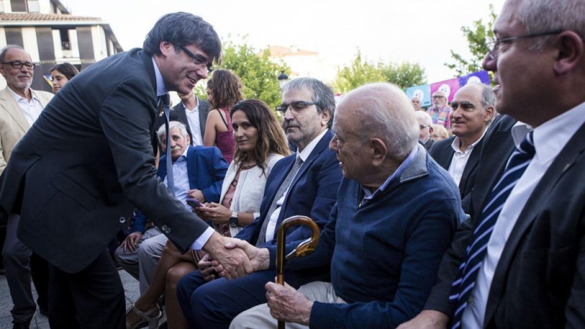 Carles Puigdemont saluda a Jordi Pujol, este martes, 1 de agosto, en la conmemoración del centenario de la muerte de Prat de la Riba, en Castellterçol.-PERIODICO (EFE / QUIQUE GARCÍA)