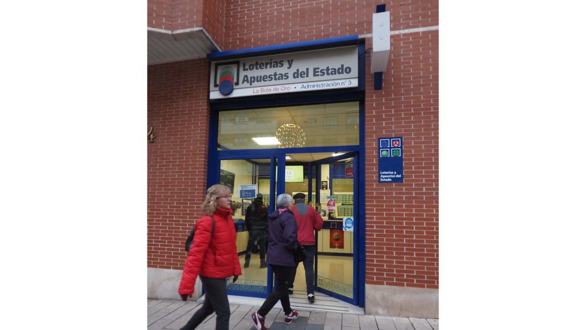 Varias personas entran en una de las administraciones de lotería de Valladolid.  PHOTOGENIC