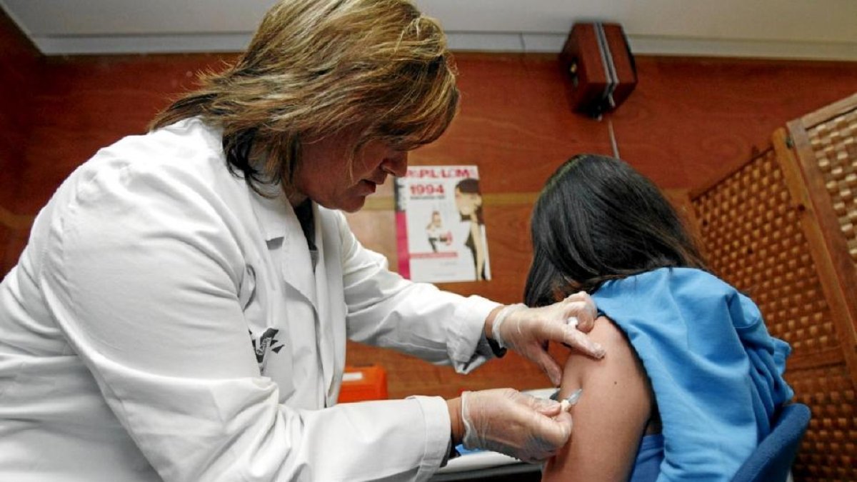 Una enfermera vacunando a una niña contra el virus del papiloma humano-EL MUNDO