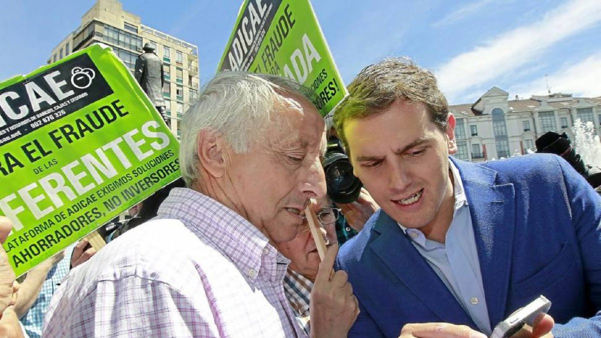 Albert Rivera muestra a un afectado por las preferentes un ‘tuit’ para explicarle lo que escribió sobre el cambio generacional en la política.-J.M. Lostau