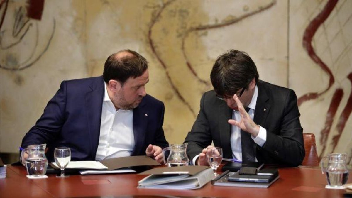 El 'president' Carles Puigdemont y el vicepresidente Oriol Junqueras conversan antes de la reunión del Govern de este martes.-FERRAN NADEU