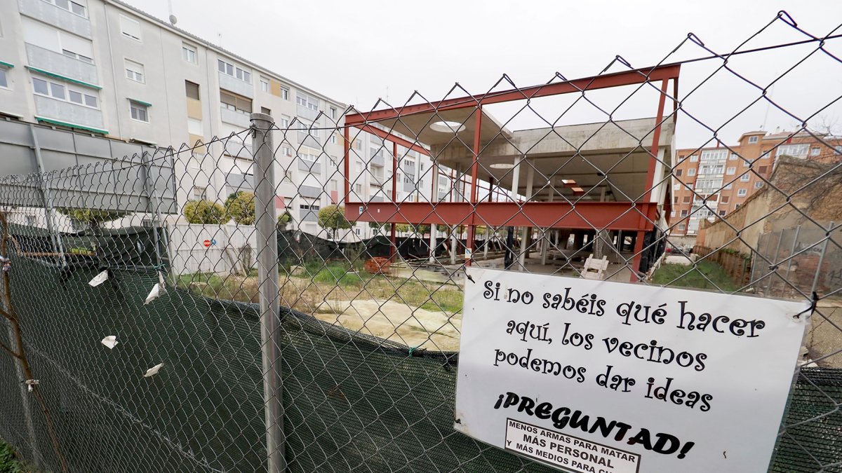 Un cartel en la valla que rodea las obras paradas del futuro centro de la Seguridad Social en Rondilla. PHOTOGENIC