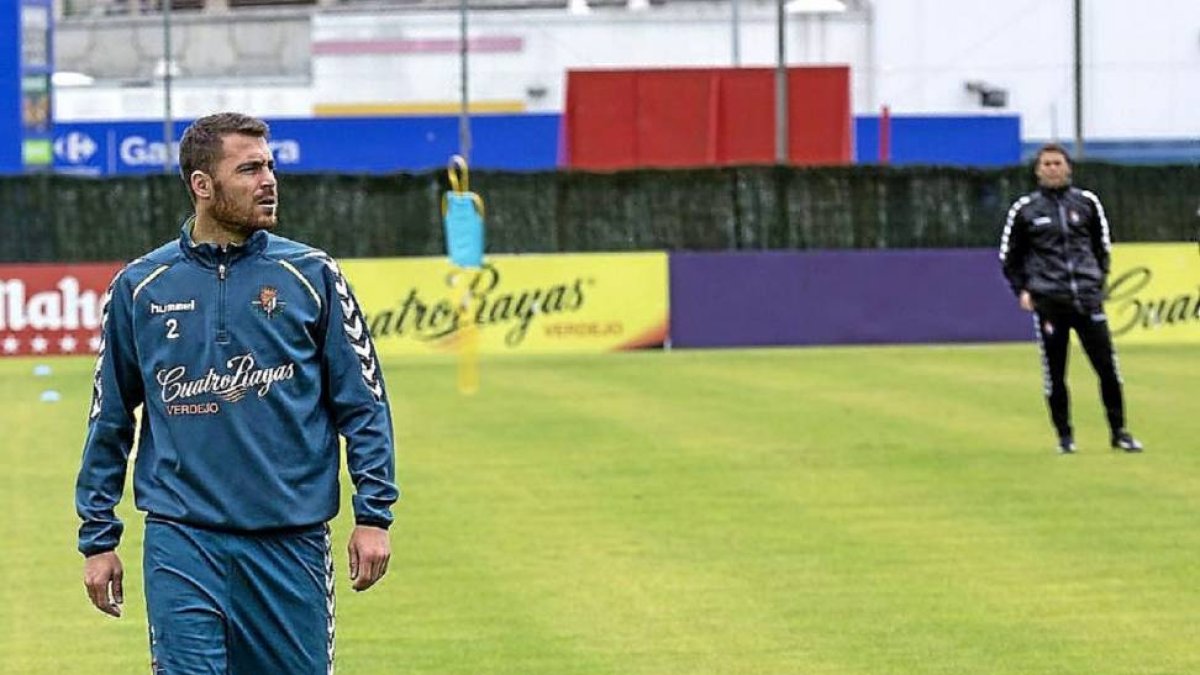 Chica anda en zapatillas por el césped de los Anexos ante la mirada de Rubi, durante el entrenamiento del lunes-Miguel Ángel Santos