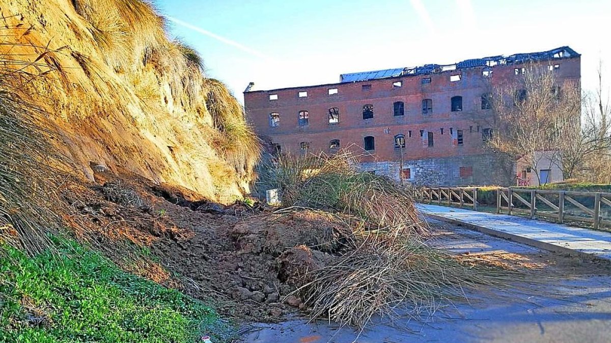 Desprendimiento del talud de la calle Calzadilla, con la antigua fábrica de harinas al fondo, ayer en Simancas.-E. M.