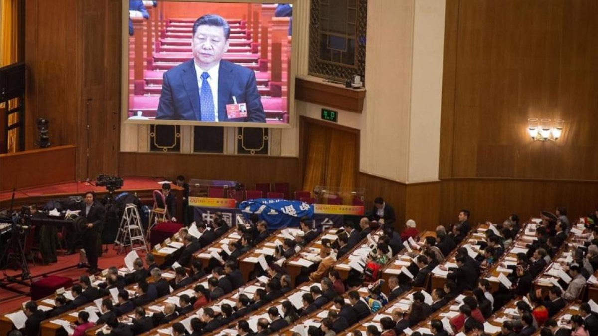 Una pantalla gigante muestra al presidente Xi Jinping durante la cuarta sesión plenaria de la XIII Asamblea Nacional Popular china, en el Gran Palacio del Pueblo, en Pekín, el 13 de marzo.-EFE / ROMAN PILIPEY