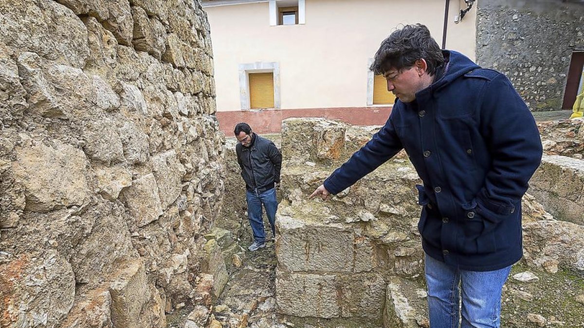 El arqueólogo Iván García señala los dos sarcófagos, en la zona donde observa su compañero David Hernández.-MIGUEL Á. SANTOS (PHOTOGENIC)