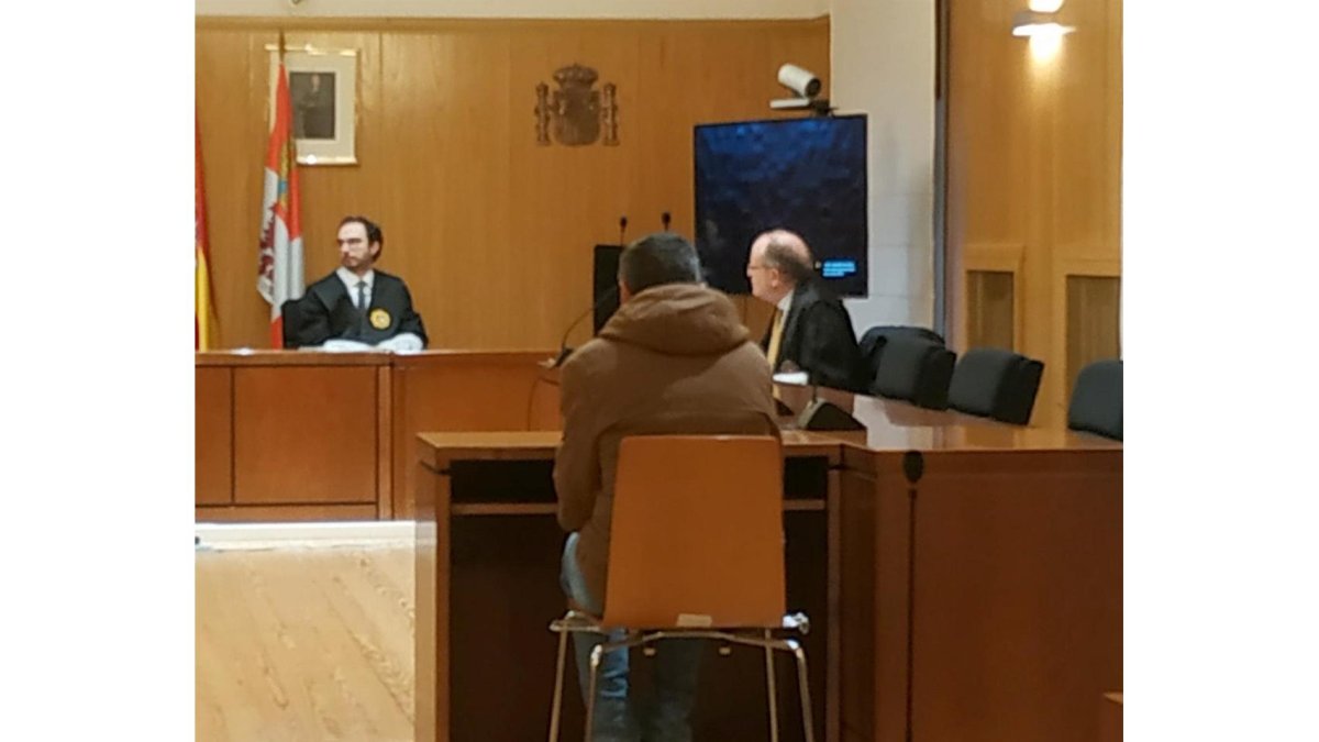 El presunto traficante, de espaldas, responde a las preguntas del fiscal durante el juicio. - EP