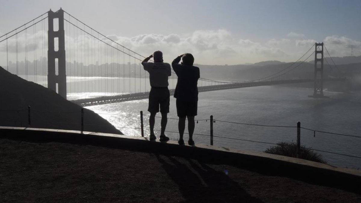 Dos turistas toman fotos del Golden Gate Bridge, en San Francisco, en una imagen de archivo-EFE / JOHN G MABANGLO