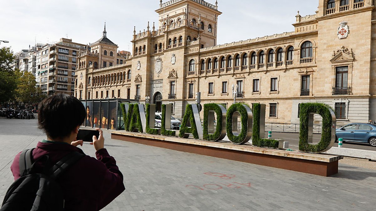 Un transeúnte fotografía el cartel vegetal sin la letra 'i'. J. M. LOSTAU