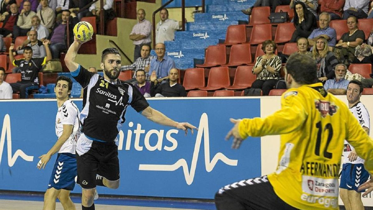 Roberto Pérez penetra y arma el brazo ante la presencia del portero del BM Aragón, Fernández-M. A. SANTOS /  PHOTOGENIC