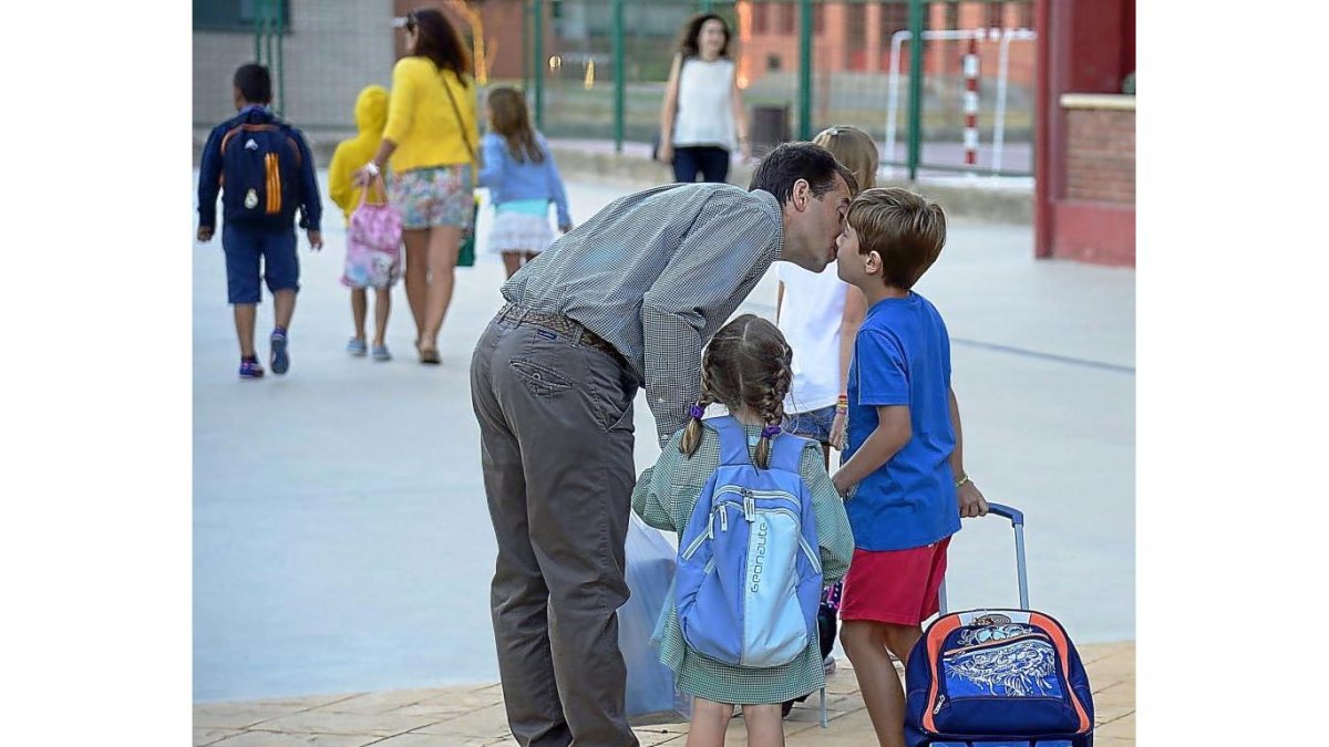 Un padre acompaña a sus dos hijos al colegio en la capital burgalesa.-ICAL